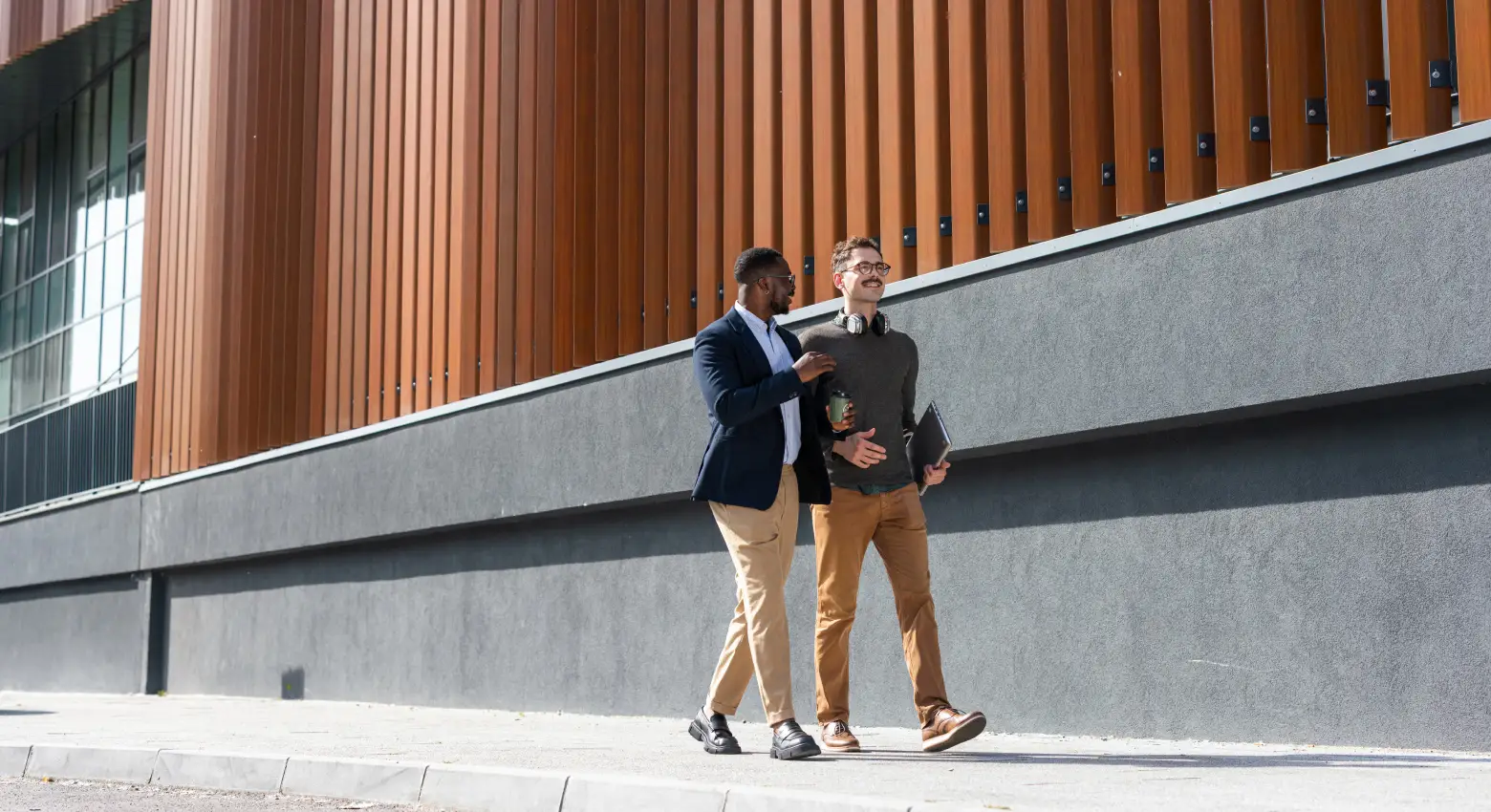 Collègues marchant à l’extérieur d’un bâtiment moderne
