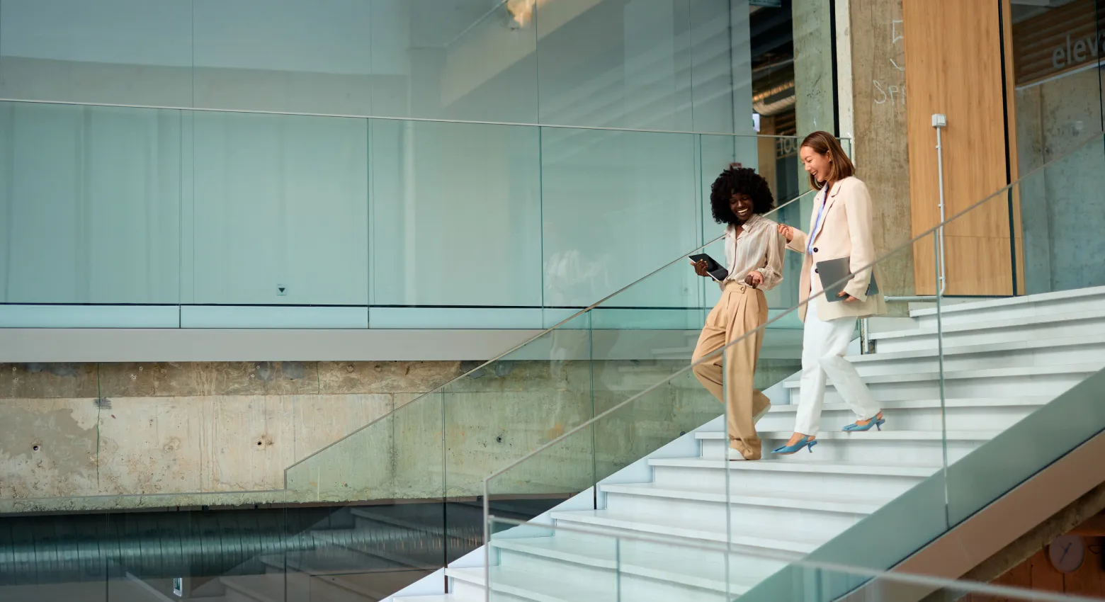 Deux femmes marchant et discutant dans un bâtiment moderne 