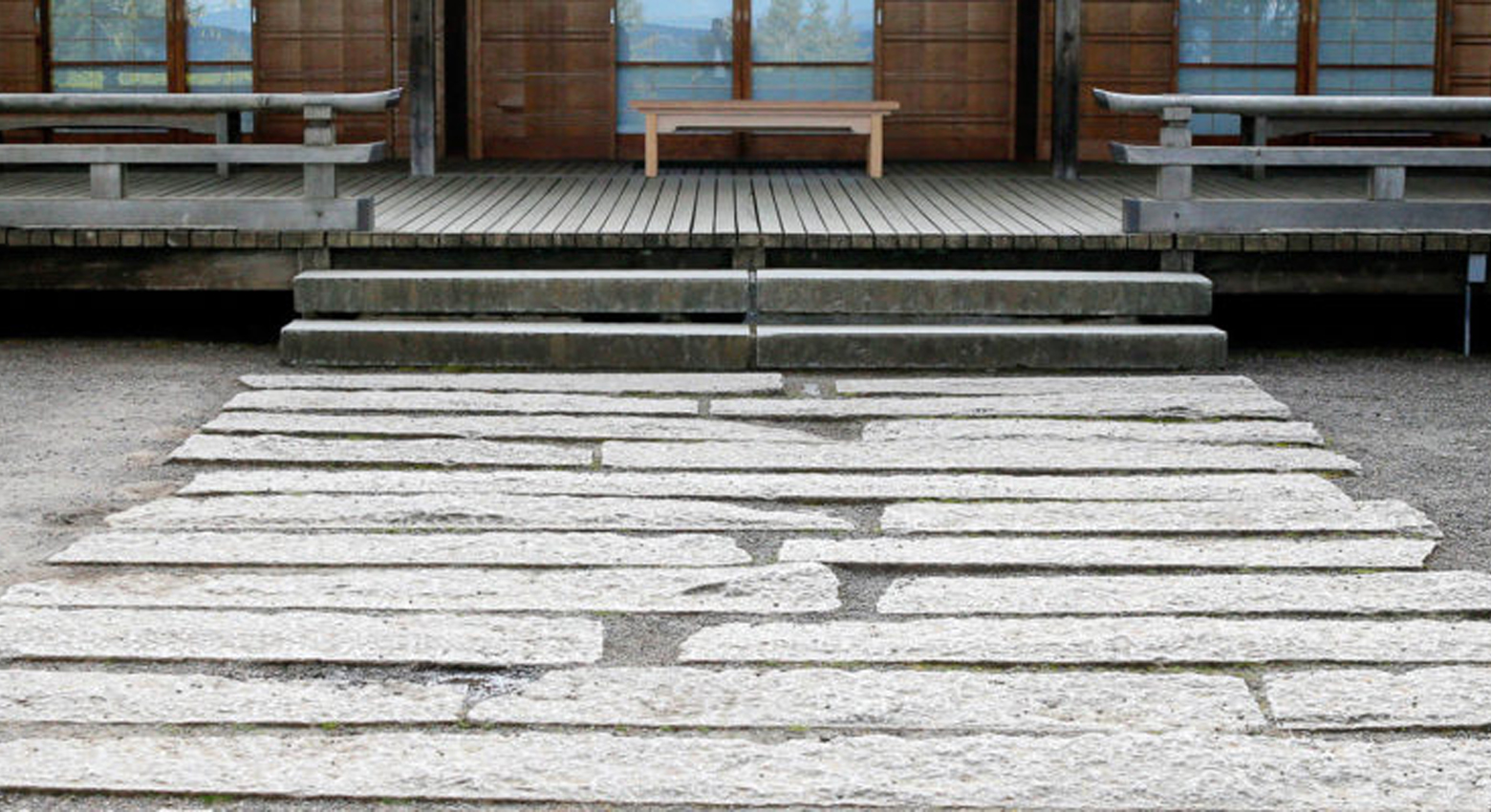 Chemin de pierres menant au bâtiment et au banc 