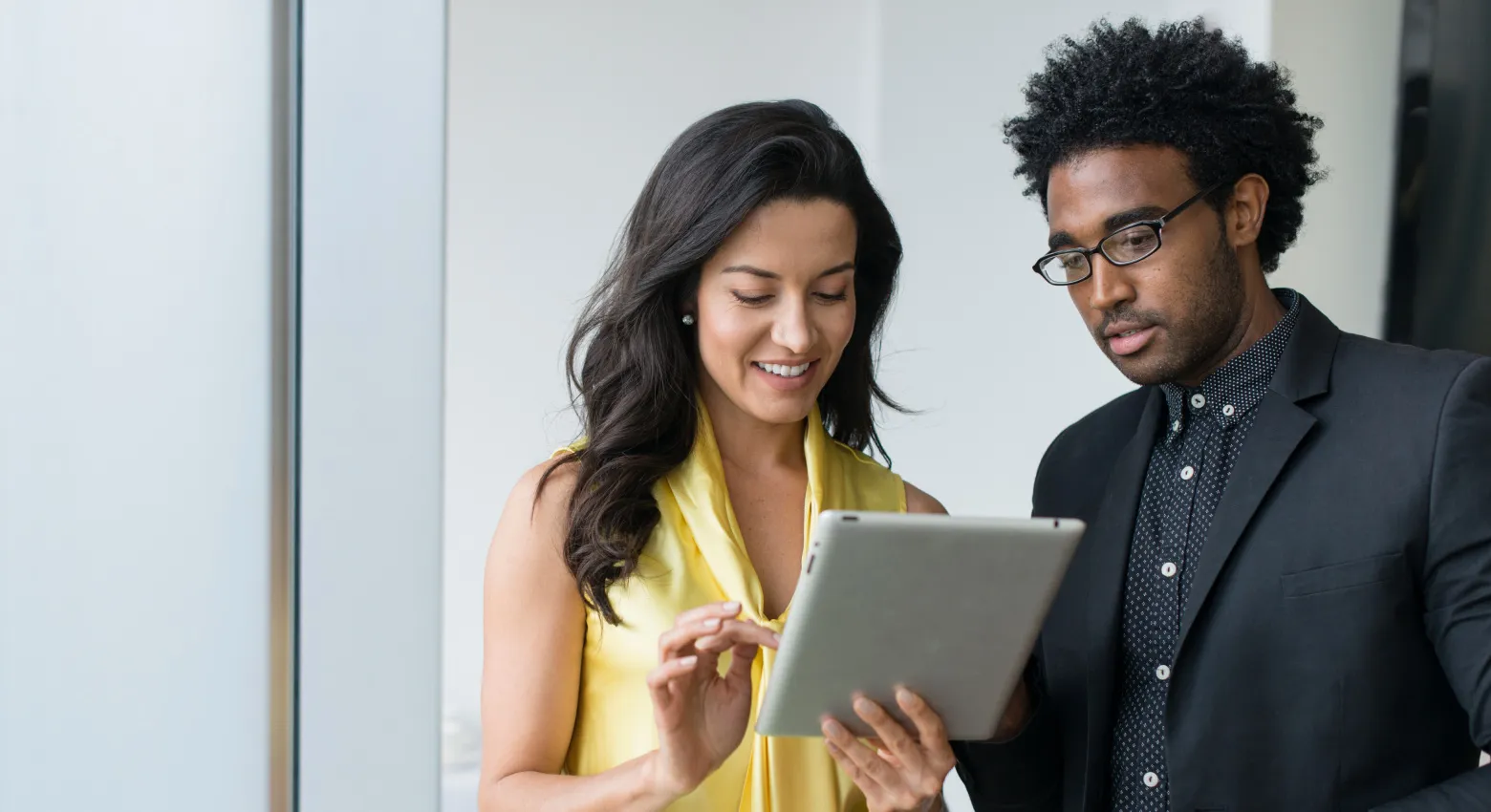 Femme et homme travaillant ensemble sur une tablette 