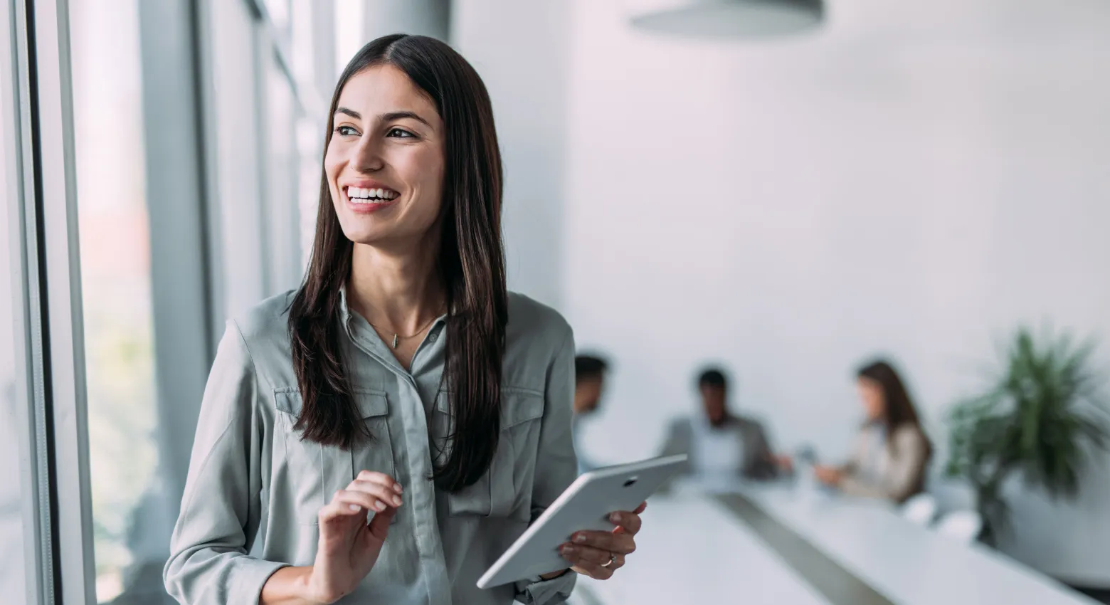 femme souriante avec une tablette au bureau